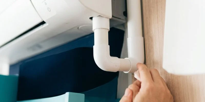 Close-up of condensate drain being flushed during aircon servicing in a Singapore condo